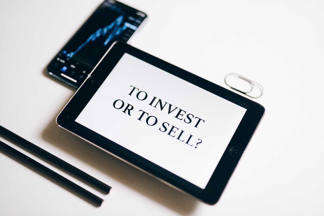 A tablet with text To Invest or To Sell? on a white background.